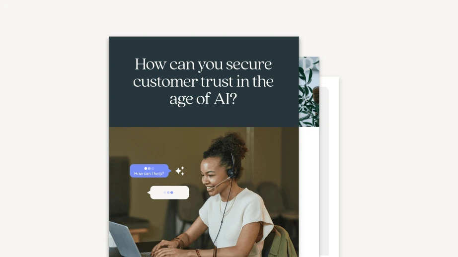 A woman wearing a headset smiles while typing on a laptop, with chat bubbles appearing on the screen. Above her, text reads: “How can you secure customer trust in the age of AI? Discover tips from our Black Friday Cyber Monday 2025 ecommerce playbook.”.