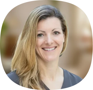 Smiling woman with long blonde hair, wearing a gray top, posed in front of a softly blurred, neutral-toned background—reflecting the approachable professionalism of Aplazo’s AI-Powered Customer Support with Kustomer AI.